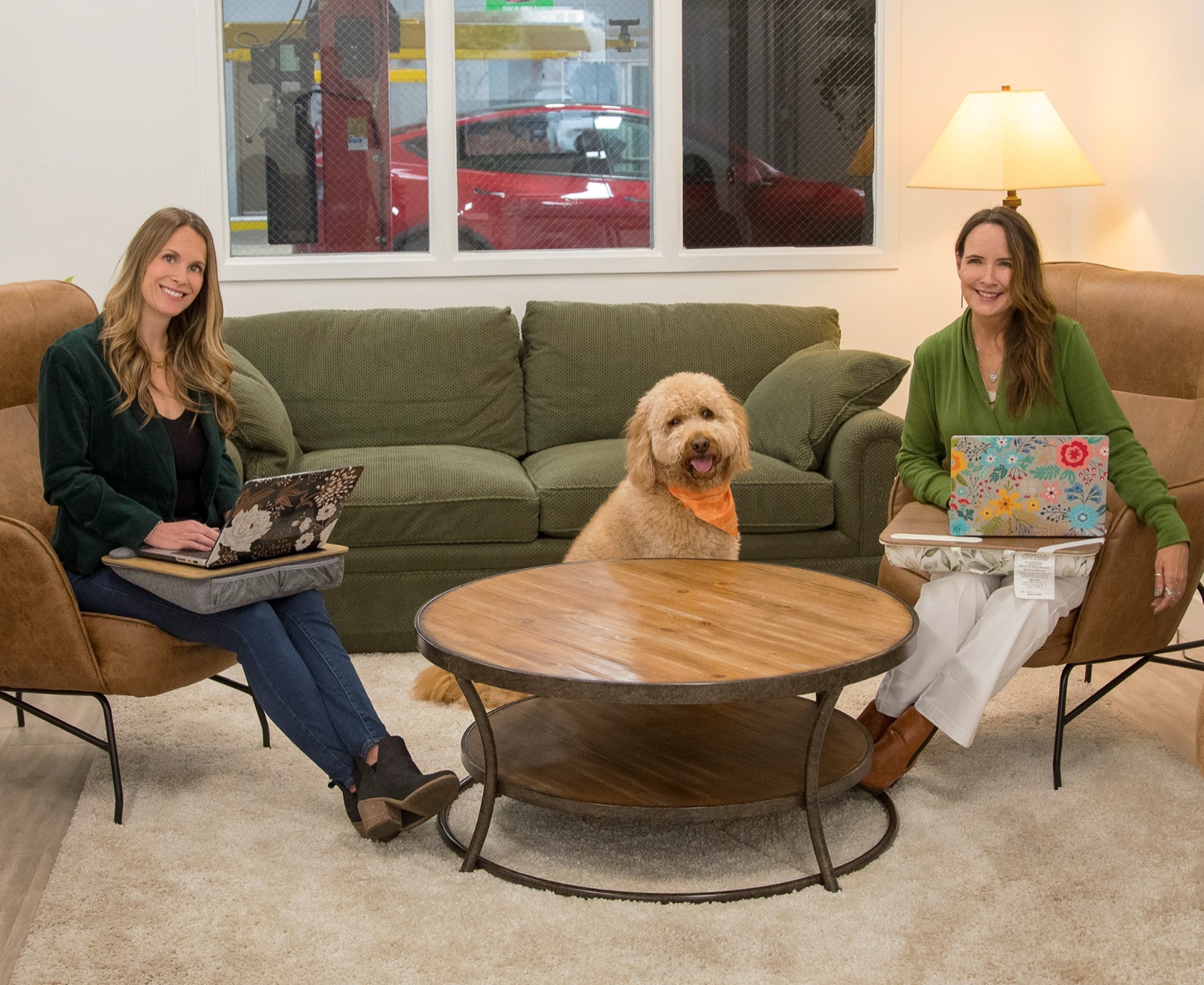 Genevieve and Shannon, founders of Revolve Motors, seated in the customer lounge with their dog